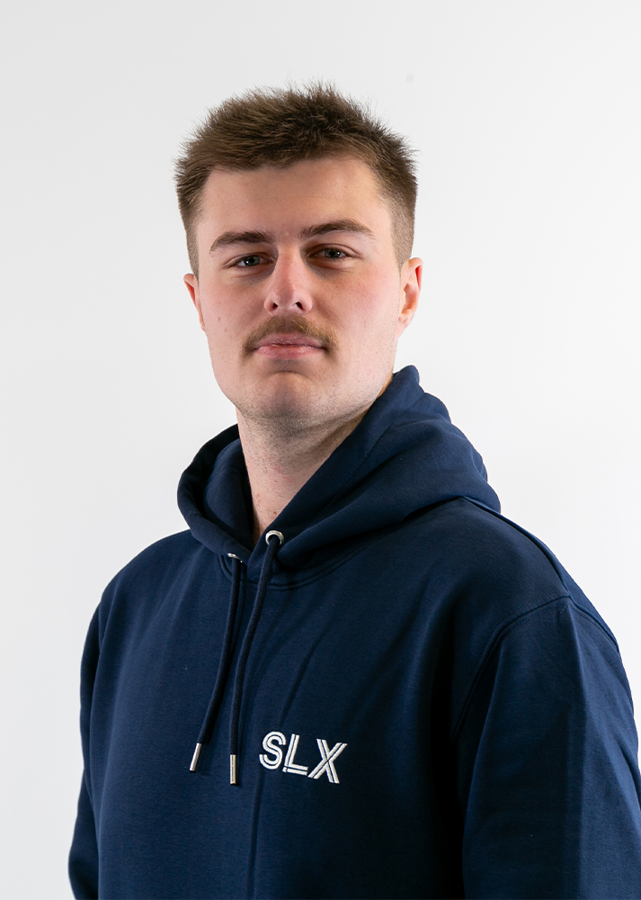 A portrait of Lewis Davis, Creative Industries Production Apprentice at SLX looking towards the camera